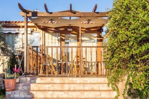 A wooden pergola structure with a stone staircase leading up to a covered area. - ELVAGO Ideal for a family with 2, 3 or 4 children.
 (Crete)
