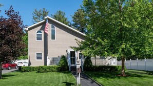 A two-story house with a front porch, a mailbox, and a small driveway.