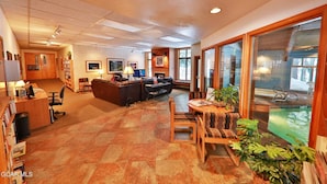 A spacious living area with a fireplace, a dining table with chairs, a sofa, and a television. - Spacious 3Bed condo 5 min from Winter Park, walk 2 Town & steps from bus stop! (Winter Park)
