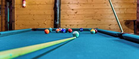 Une table de billard avec des billes et une queue de billard.
