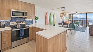 Une cuisine moderne avec des meubles en bois, un four à micro-ondes encastré et un grand îlot central.