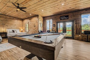 A wooden interior with a pool table, a bed, and a sign that says 'come together'.