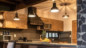 Una cocina con armarios de madera, una pared de acento de piedra y una barra con taburetes.