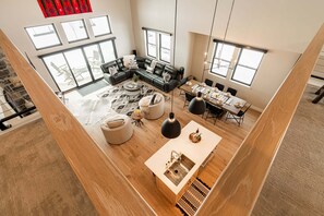 A spacious living area with a large sectional sofa, a dining table, and a kitchen island with a sink.