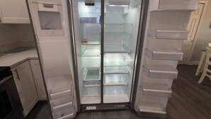 Eine Küchenzeile mit Einbaukühlschrank, Spüle und Schränken.