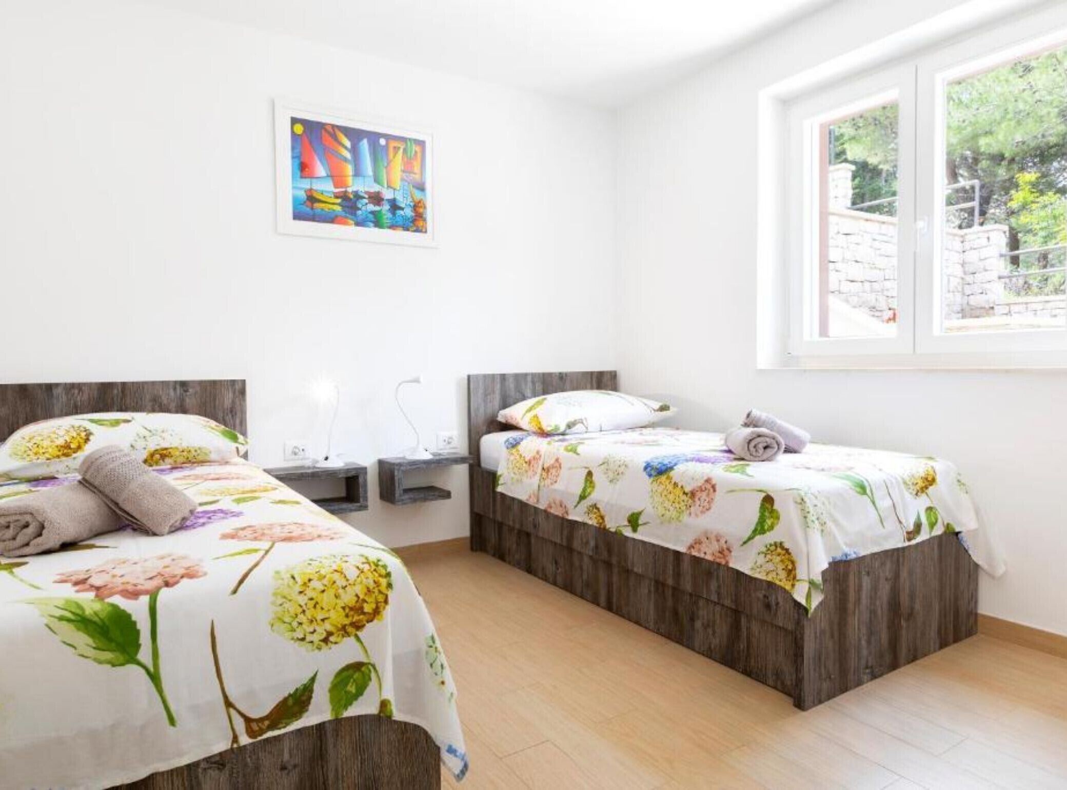 Un dormitorio con dos camas, una ventana y un cuadro en la pared.