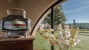 Ein altes Radio auf einer Holzkabine, ein Blumenstrauß und Blick auf einen Golfplatz durch ein großes Fenster.