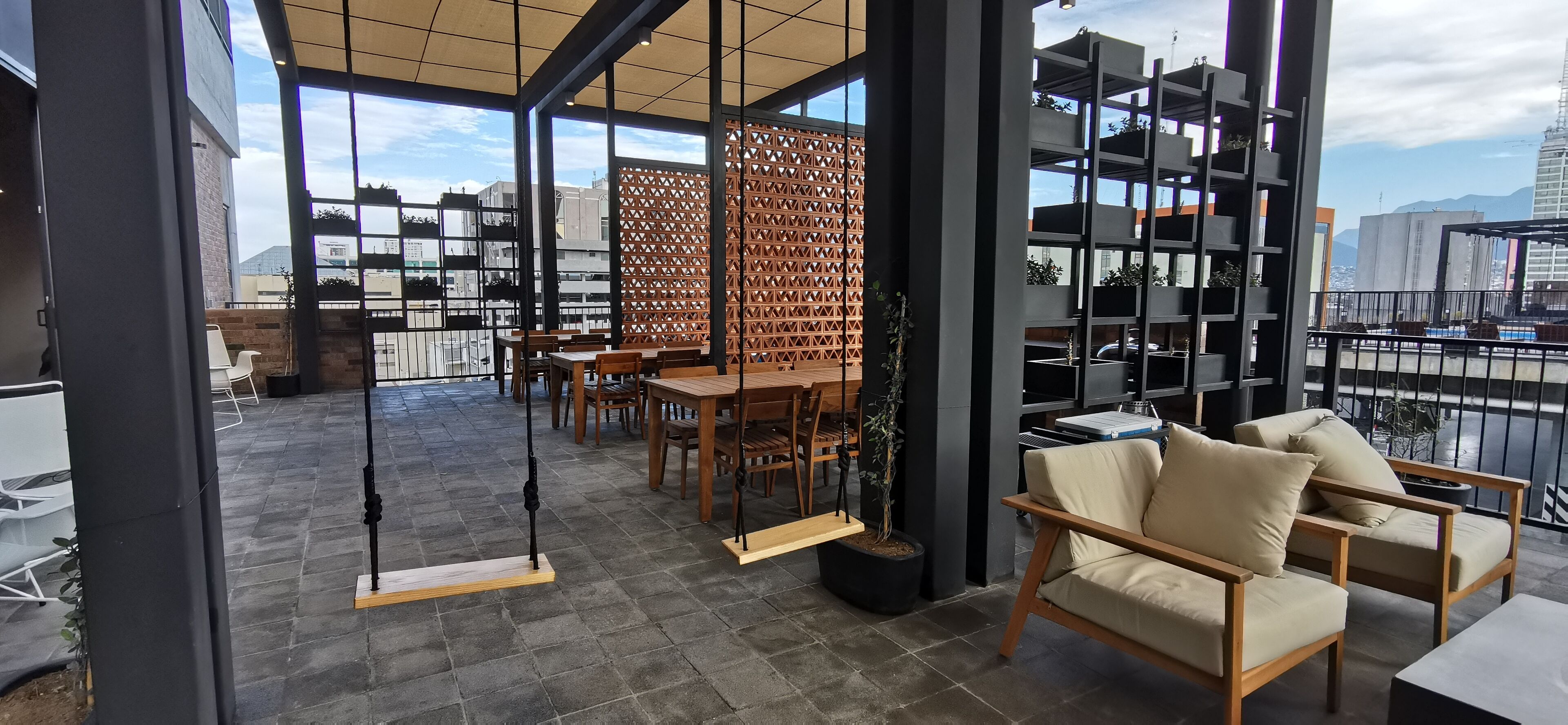 Un espacio interior moderno con techos altos, ventanas amplias y vistas a la ciudad.