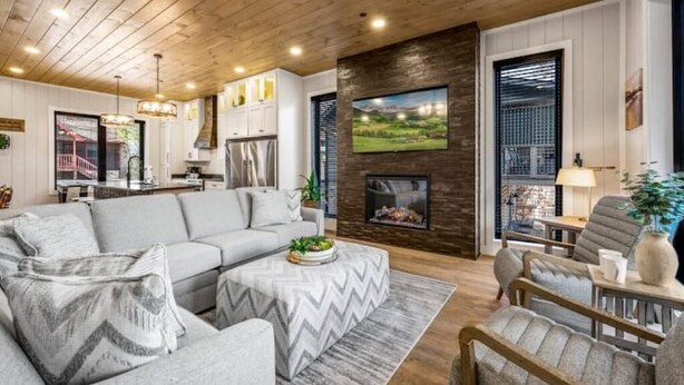 A modern living room with a fireplace, a sofa, a coffee table, and a dining area.