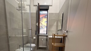 Un baño moderno con cabina de ducha de vidrio, inodoro y lavabo.