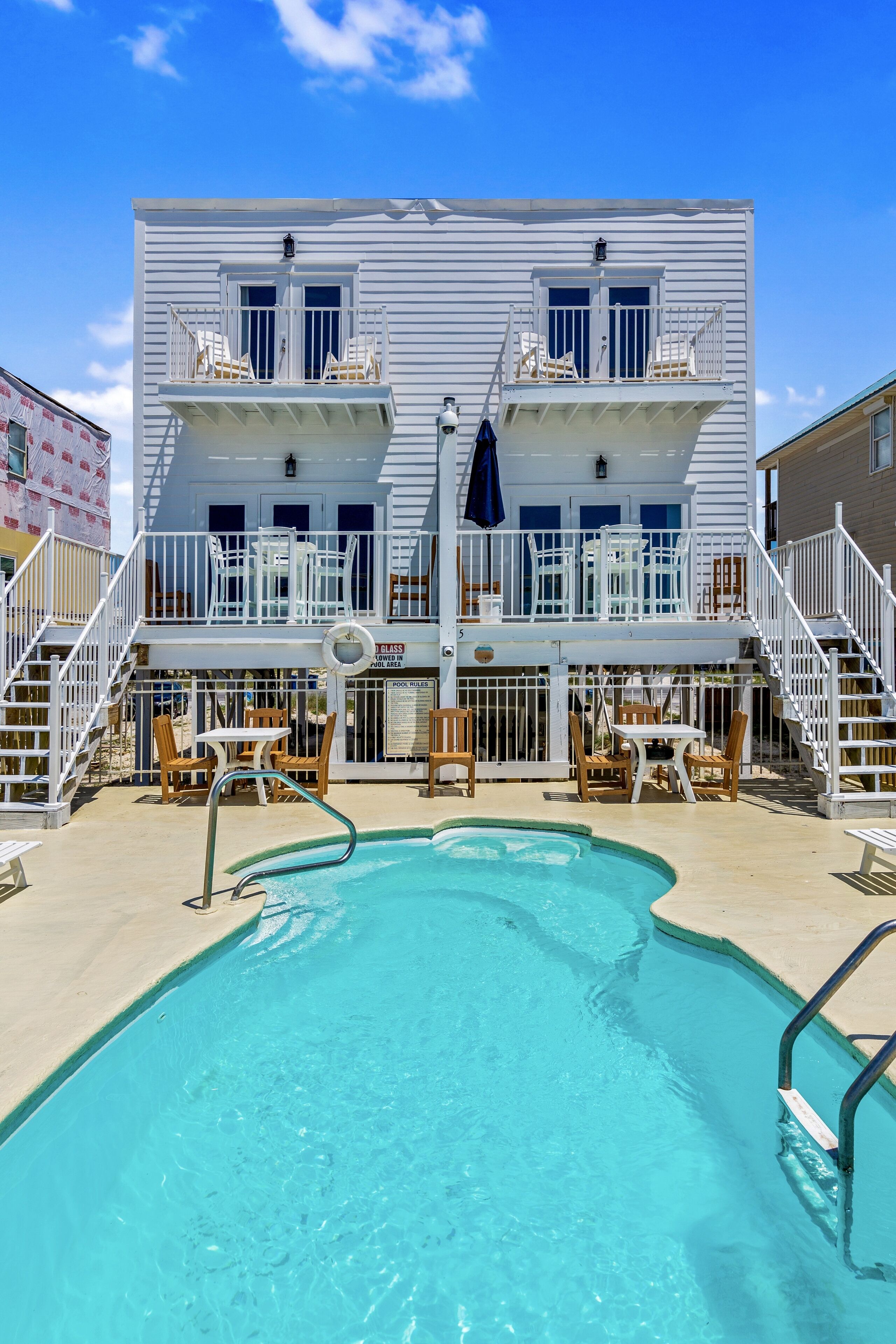 Een buitenzwembad, ligstoelen bij het zwembad