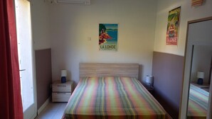Een slaapkamer met een bed, twee nachtkastjes, een raam en een deur.