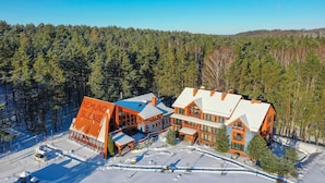 Een chalet met meerdere gebouwen, een skilift en een besneeuwd landschap.