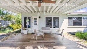 An outdoor patio with a ceiling fan, a table, and two chairs. - Beach Retreat Downtown Hot Tub (Delray Beach)