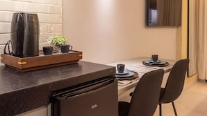 Una cocina moderna con aire acondicionado integrado, una cafetera y un comedor con sillas y una mesa.