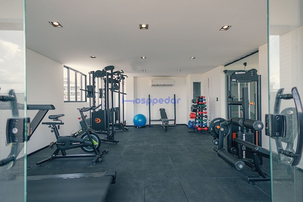 Une salle de sport équipée de matériel d’exercice, avec un ballon d’exercice bleu et un porte-poids.