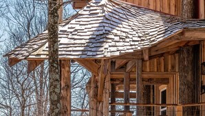 A wooden treehouse with a staircase and a small balcony. - 2BR, 1BA  HAND BUILT MOUNTAIN TOP TREE HOUSE with Hot tub (Nashville)