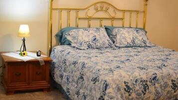 Ein Schlafzimmer mit einem Bett, einem Nachttisch, einer Lampe und einer Uhr.