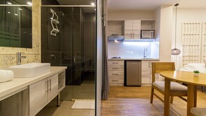 A modern bathroom with a glass shower enclosure, a large sink, and a vanity.