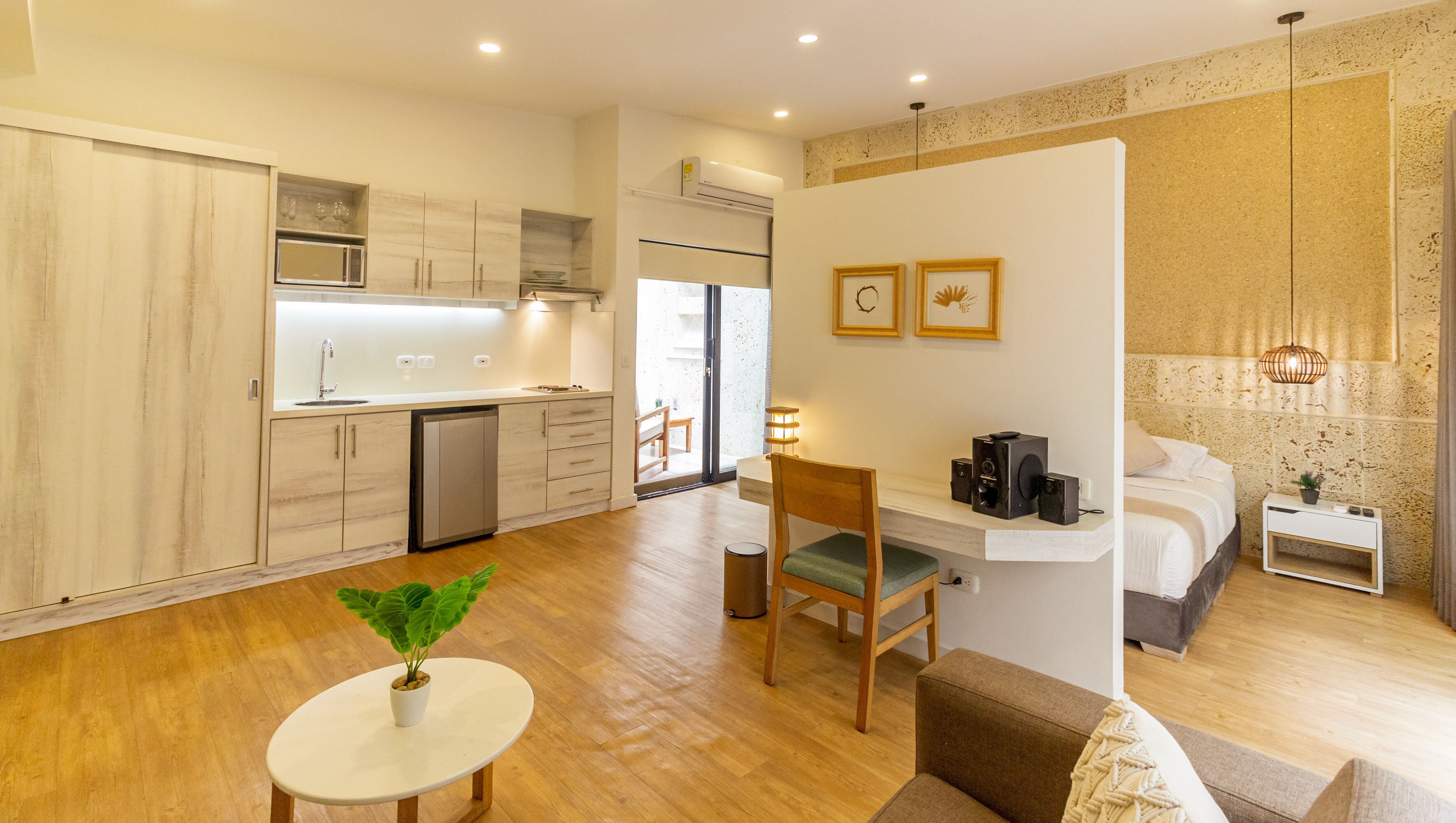 A modern apartment with a kitchen, dining area, and a bedroom.
