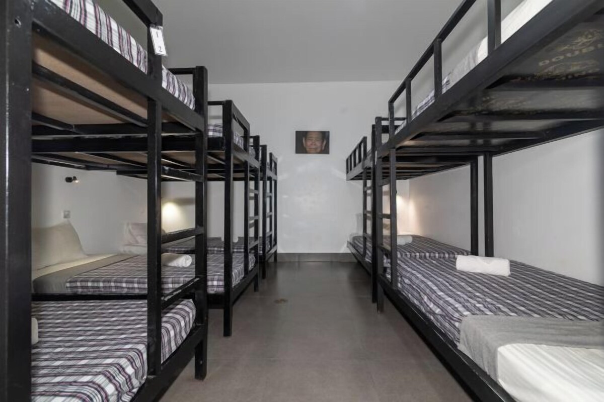 A room with bunk beds, a small table, and a wall-mounted picture.