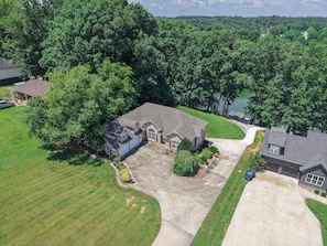 A residential property with a large driveway, a garage, and a lawn.