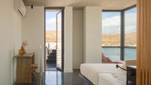 Ein modernes Schlafzimmer mit großem Fenster, einem Bett und einem Schreibtisch mit einer Vase.