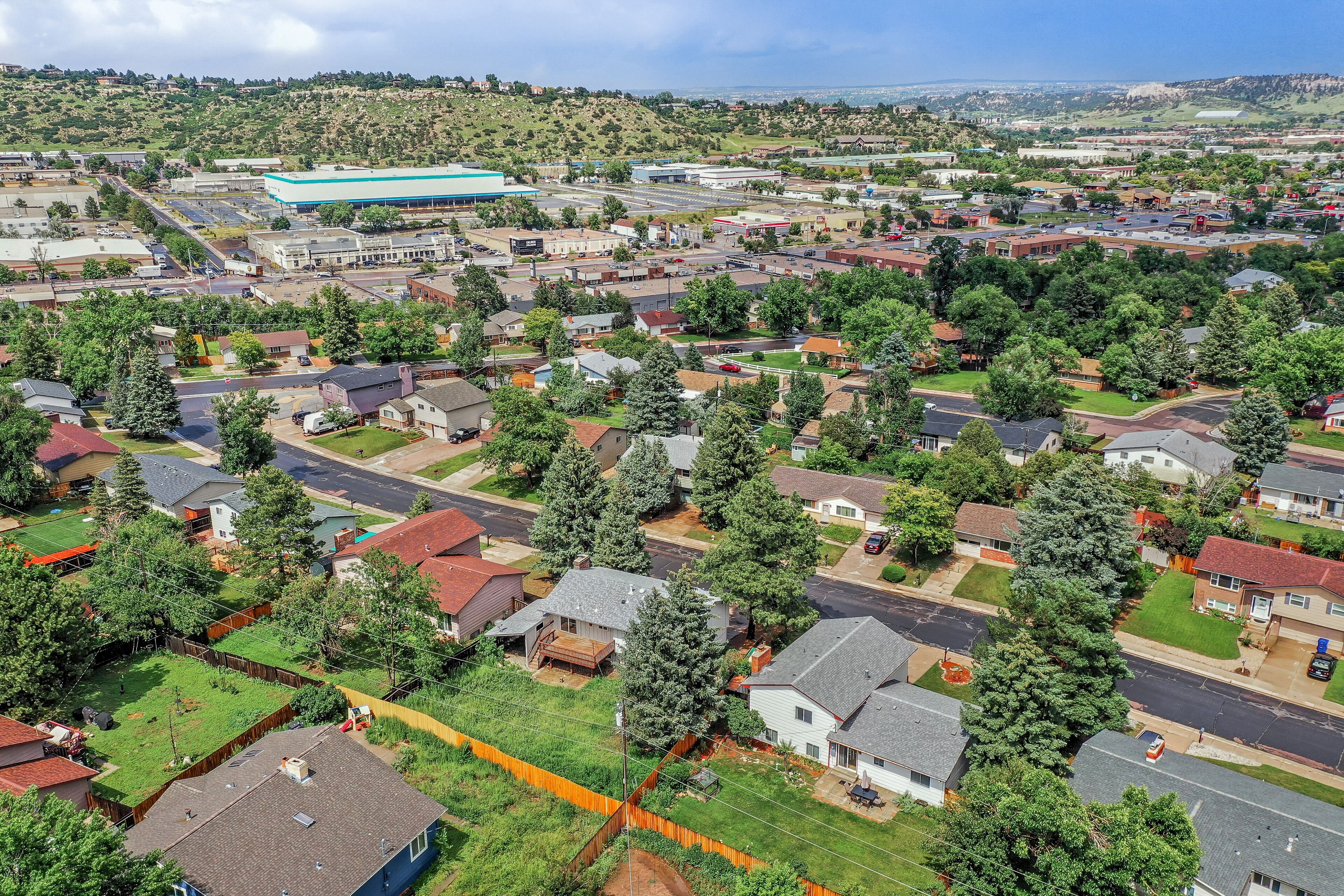 An aerial view of a residential area with houses, roads, and a large industrial building.