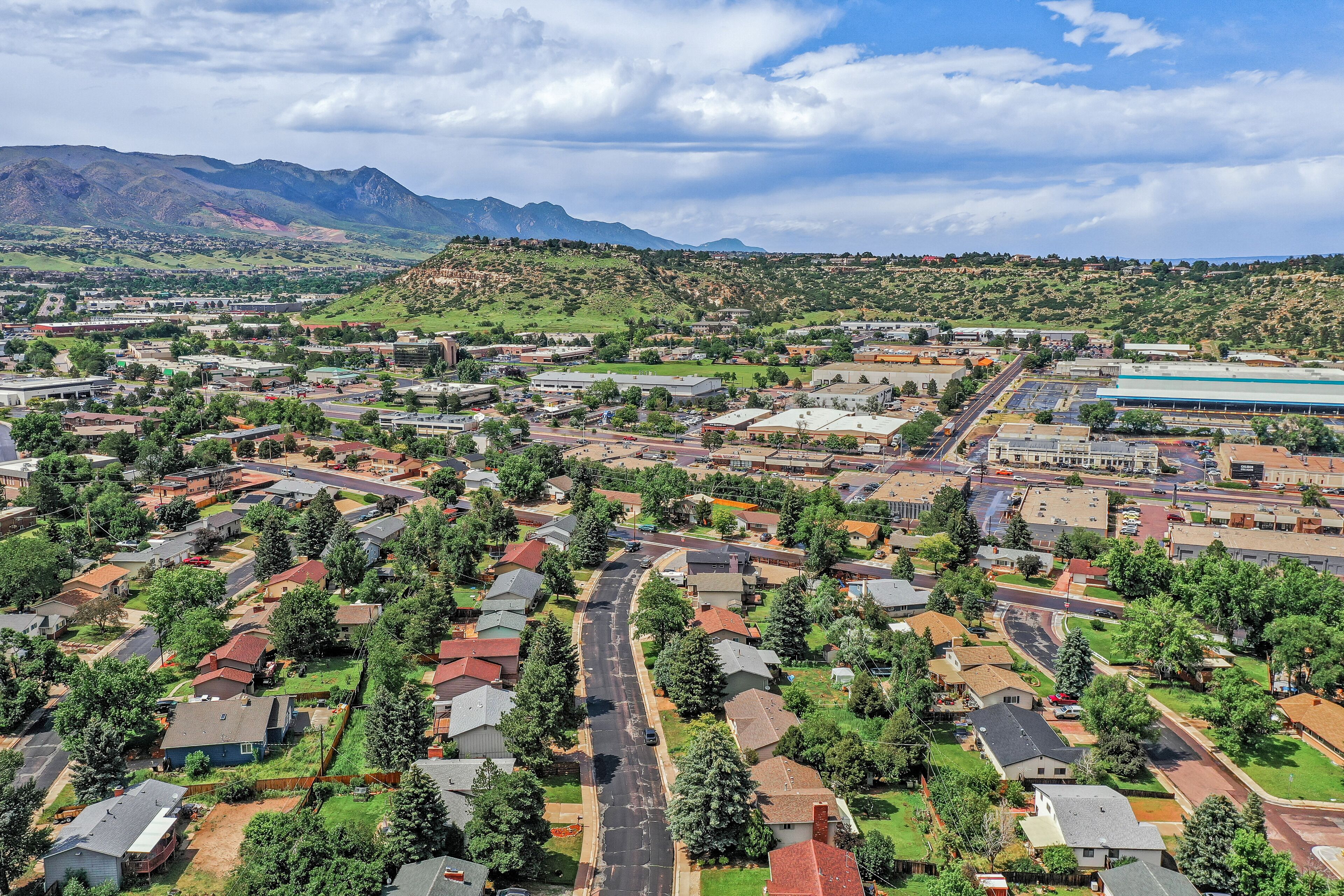 An aerial view of a residential area with houses, roads, and a large building complex.