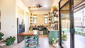 Una cucina moderna con isola centrale, elettrodomestici in acciaio inossidabile e un'ampia finestra con vista su un giardino.
