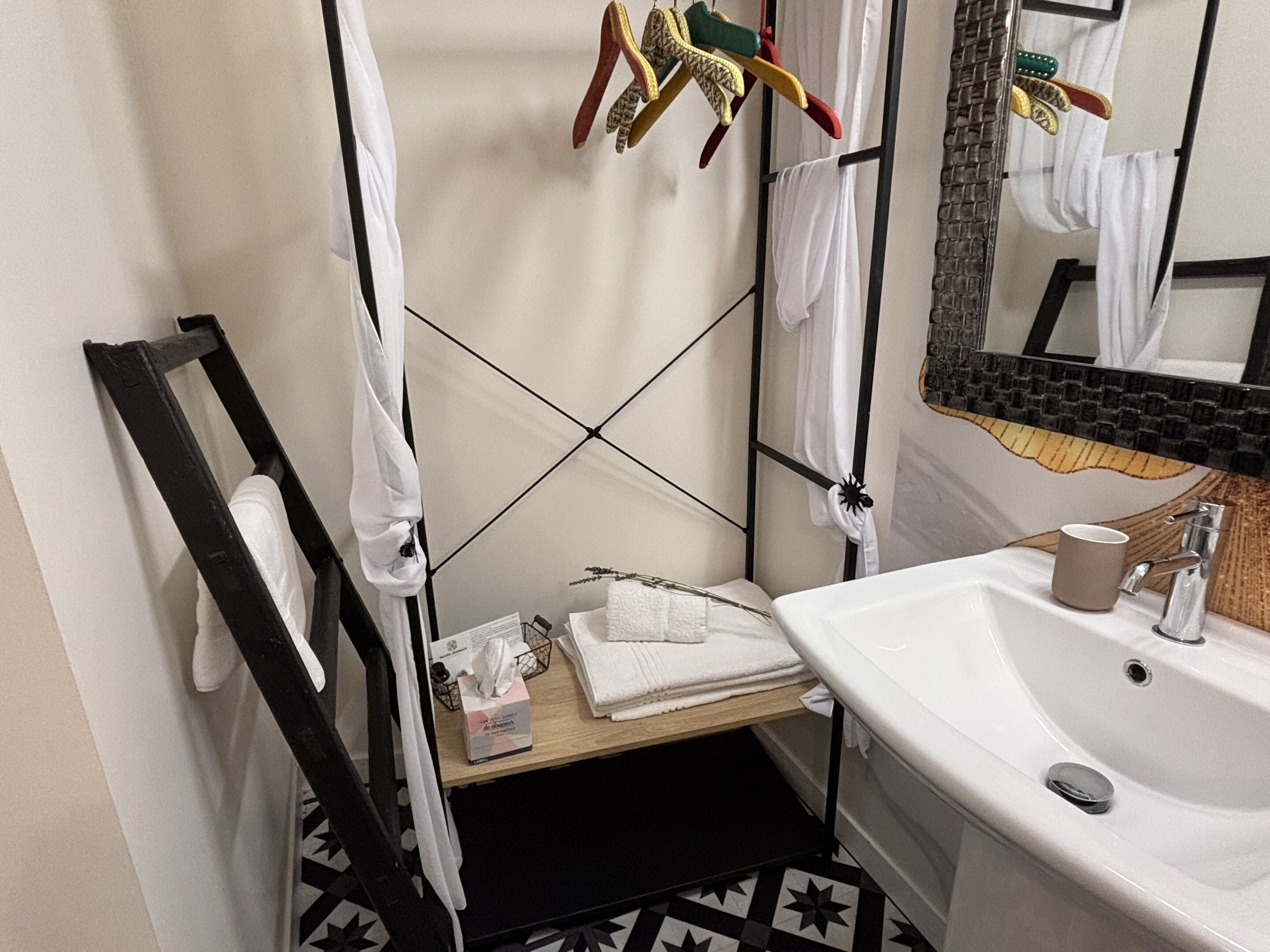 A bathroom with a white sink, a mirror, and a towel rack.