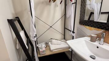 A bathroom with a white sink, a mirror, and a towel rack.