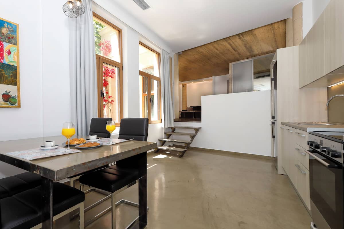 Une cuisine moderne avec un coin repas, un plafond en bois et une vue sur le salon.