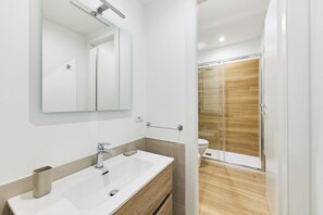 Een douche, een bidet, handdoeken, toiletpapier