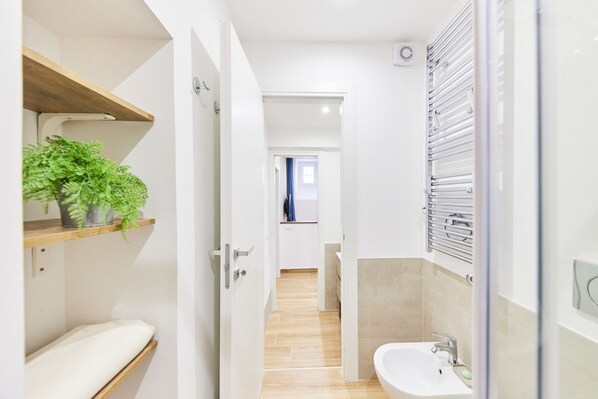 Een douche, een bidet, handdoeken, toiletpapier