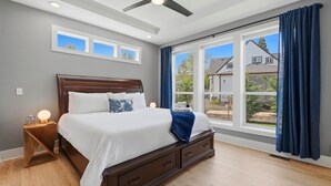 A bedroom with a large bed, a ceiling fan, and a view of the outside. - Luxury 3 King Suite Retreat 3 Blocks to Downtown! (Carlton)