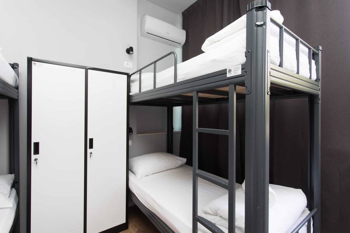 A bunk bed room with a wardrobe and an air conditioning unit.
