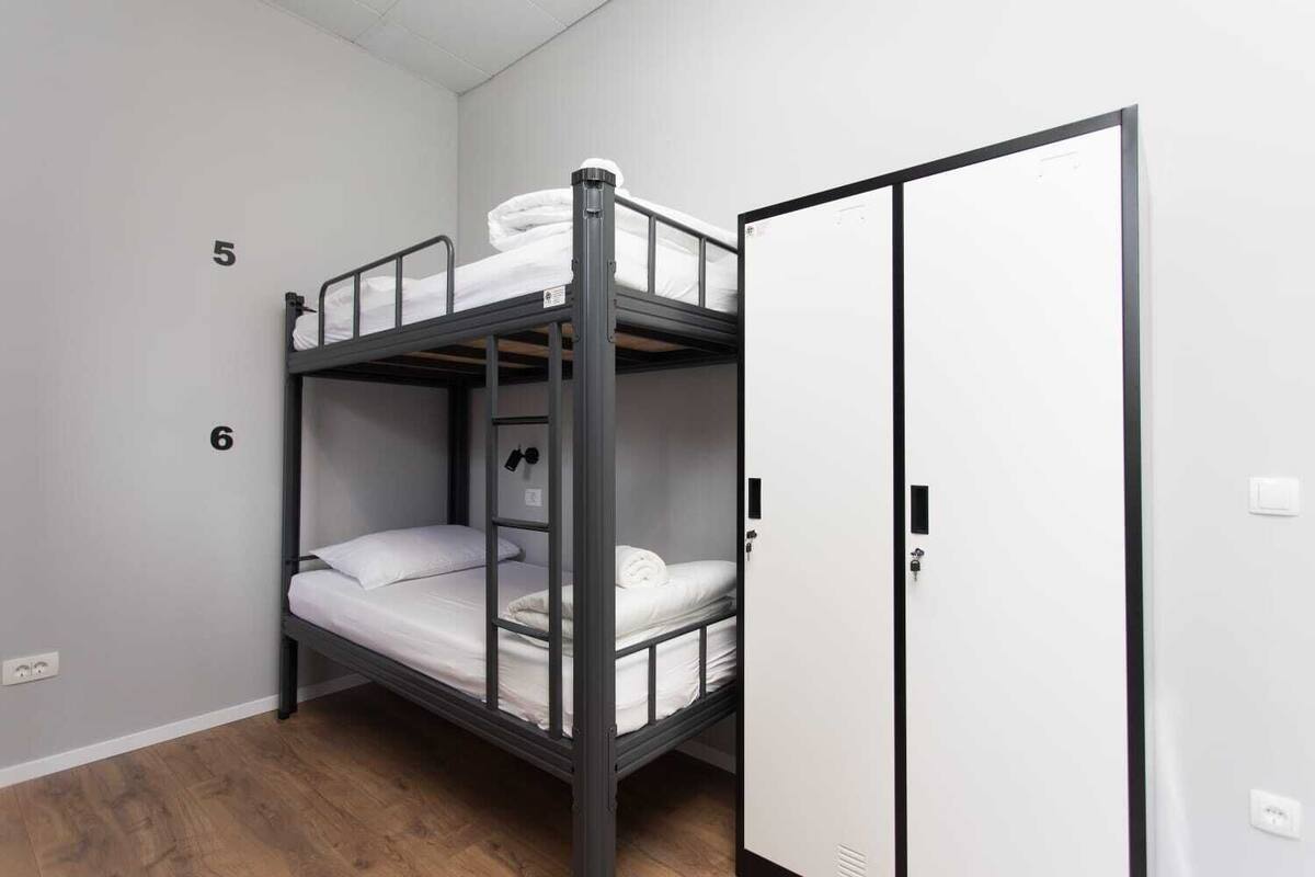A bunk bed room with a wardrobe and a door.
