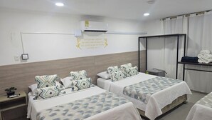 A hotel room with two beds, a bedside table, a nightstand, a mirror, a wardrobe, and a wall-mounted air conditioner. - Hotel Rodadero Dorado (Santa Marta)