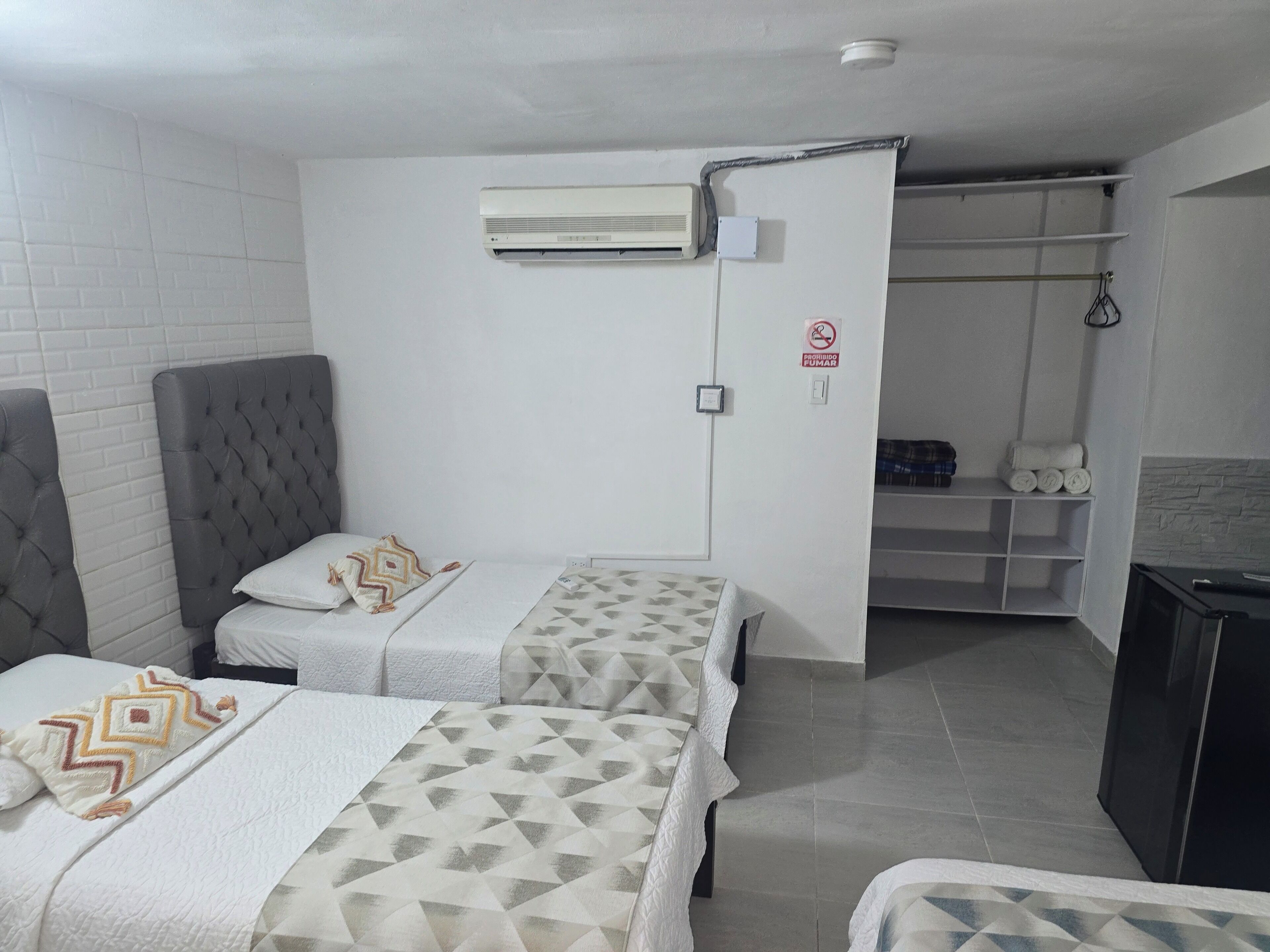 Une chambre d’hôtel avec deux lits, une armoire, un radiateur et un porte-serviettes.
