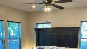 A bedroom with a dark wood bed, a ceiling fan, and a patterned rug. - Party walk 3 minute/ Downtown 5 minutes away/ Spring break at Pearl. (San Antonio)