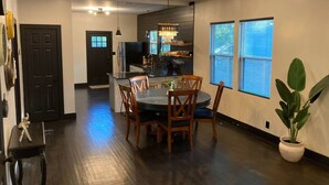 A modern kitchen with a central island, dining table with chairs, and a potted plant. - Party walk 3 minute/ Downtown 5 minutes away/ Spring break at Pearl. (San Antonio)