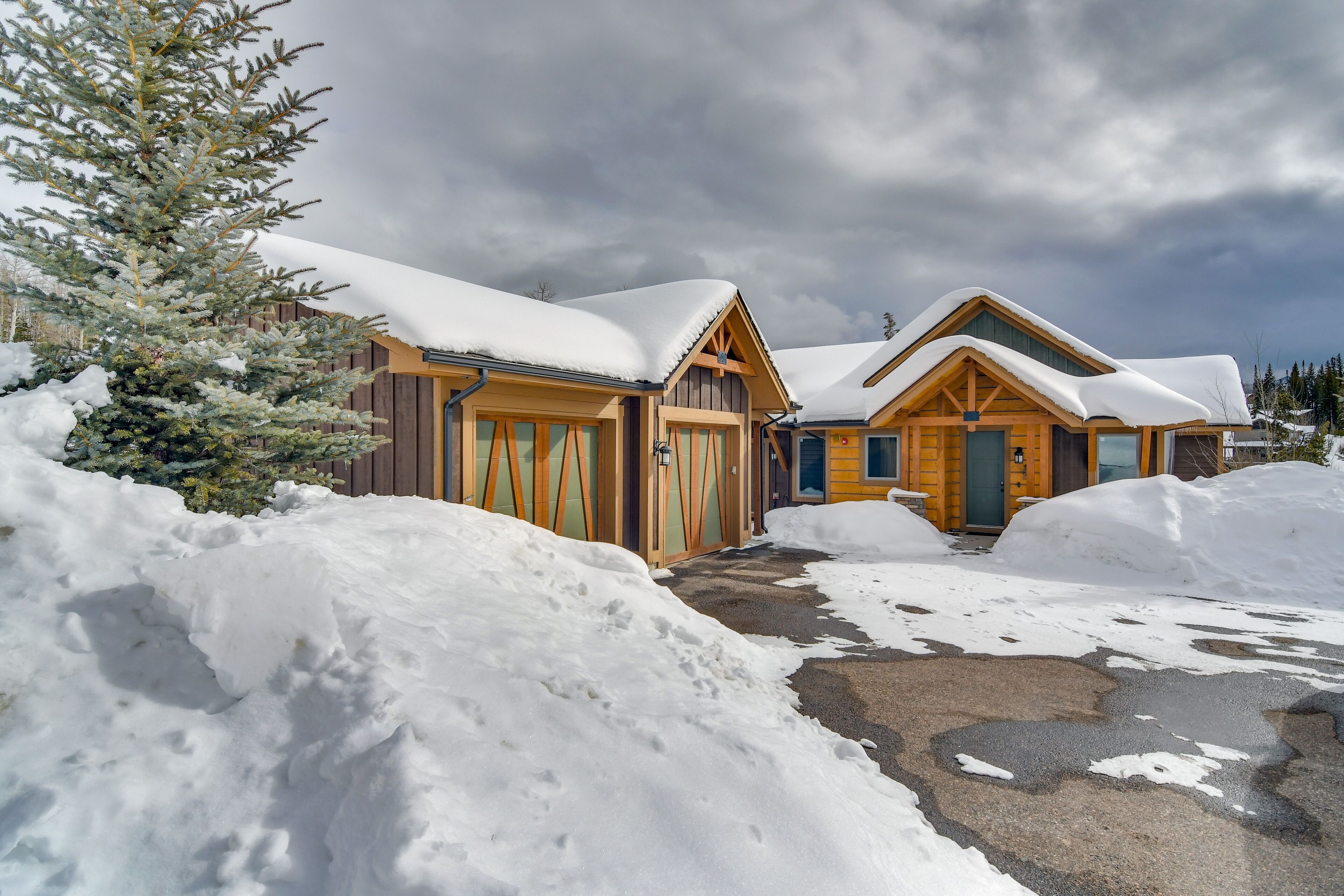 Un chalet en bois, avec des toits recouverts de neige et un ciel dégagé.