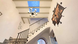 A staircase with a modern design, a chandelier, and a map on the wall. - Nomadara - Boutique B&B (Coin)