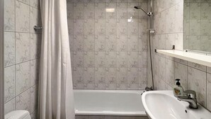 A bathroom with a shower, a toilet, and a sink.
