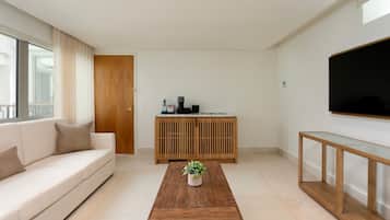 Een moderne woonkamer met een bank, salontafel, houten kast en een flatscreen televisie.