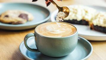 Uma chávena de café com arte de latte num pires.