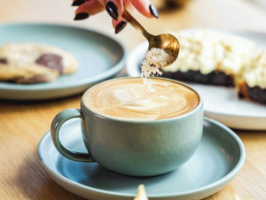 Uma chávena de café com arte de latte num pires.