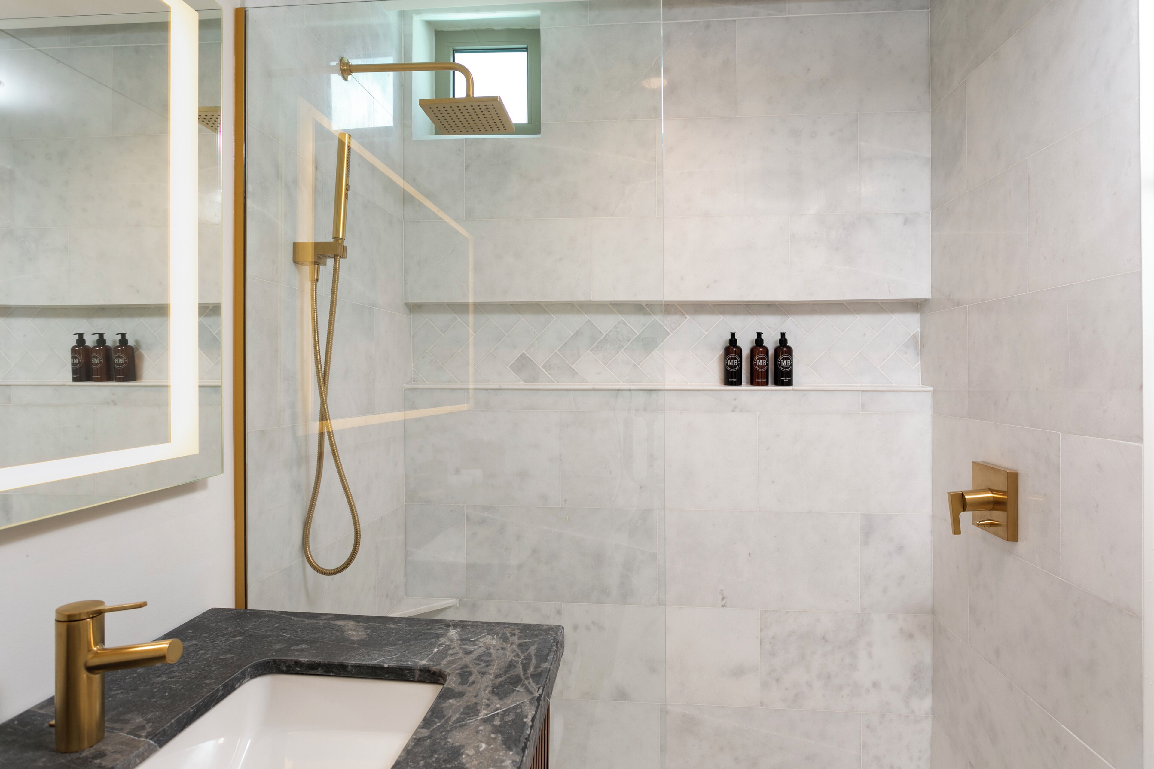 A modern bathroom with a shower, a sink, and a mirror.