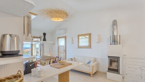 A modern kitchen with a central island, a built-in stove, and a view of the sea. - Casa Margarita with seaview and pool (Tertenia)